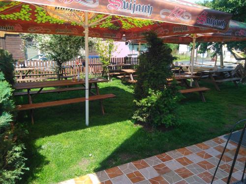 a group of tables and benches under an umbrella at Penzion Dřevěnka in Osečná