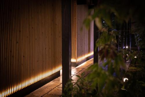 a hallway with lights on a wall at night at Oyado Den Rikyu in Yufuin