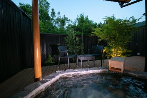 a small pool on a deck with a table and chairs at Oyado Den Rikyu in Yufuin