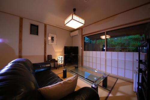 a living room with a couch and a glass table at Oyado Den Rikyu in Yufuin