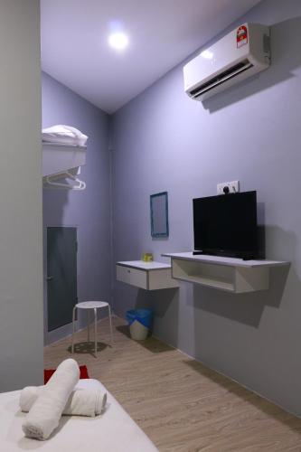 a room with a bed and a tv on a wall at The b'Hotel in Kajang