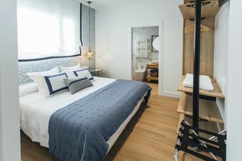 Schlafzimmer mit einem Bett mit blauen und weißen Kissen in der Unterkunft The Lucky Flats - Poeta Quintana in Alicante