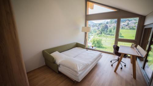 a bedroom with a bed and a large window at Seaside-Lodge, Top Apartment in Spiez