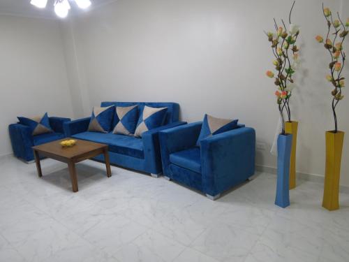 un sofá azul y una mesa en una habitación en Apartments Sunny Sky RedSeaLine Hurghada, en Hurghada