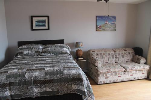 a bedroom with a bed and a couch at Robbins by the Sea in Bonavista