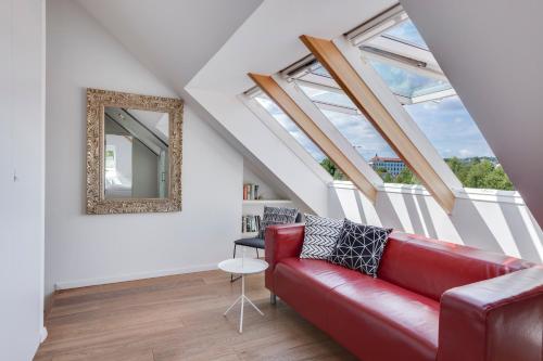 a living room with a red couch and a mirror at Fine Ljubljana Apartments in Ljubljana
