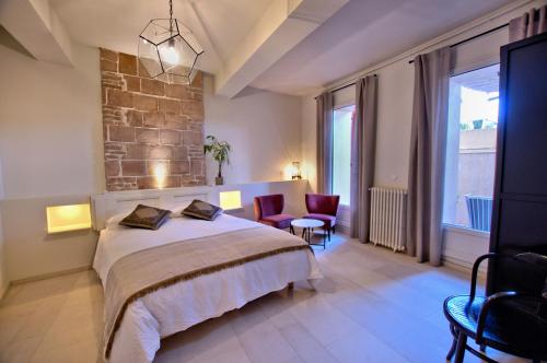 a bedroom with a large bed and chairs in it at Villa Caroline - Chambres d'Hôtes in Albi