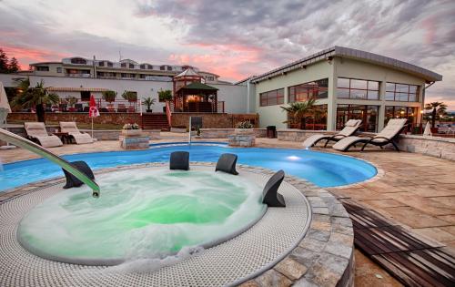 a house with a hot tub in the backyard at Wellness & Spa Hotel Kaskady in Sliač