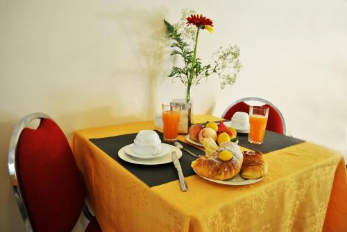 a table with a yellow table cloth with food on it at Hotel Columbia in Palermo