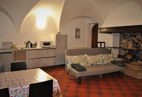 ein Wohnzimmer mit einem Sofa und einer Küche in der Unterkunft Appartamento Le Volte in Toscolano-Maderno