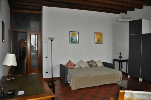 ein Wohnzimmer mit einem Sofa und einem Tisch in der Unterkunft Appartamento Le Volte in Toscolano-Maderno