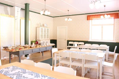 una sala da pranzo con tavoli bianchi e sedie bianche di B&B Taipaleenniemi a Savonlinna
