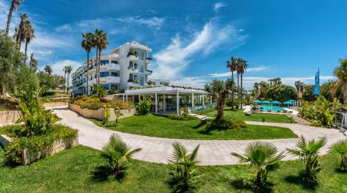 a resort with a swimming pool and palm trees at Acacia Palace in Marina di Ragusa