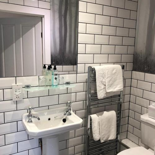 a white bathroom with a sink and a mirror at McKays Hotel in Pitlochry