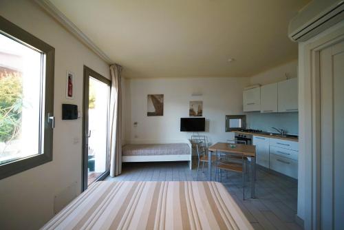 a kitchen and dining room with a table and a window at Holiday home Isola Rossa in Isola Rossa