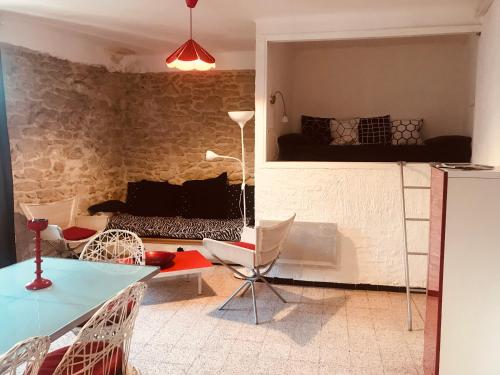 サン・レミ・ド・プロヴァンスにあるM&S - Apartment in Saint Rémy de Provenceのリビングルーム(テーブル、椅子、ソファ付)