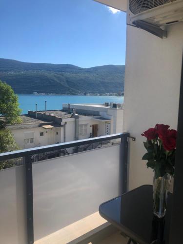 a balcony with a table and a view of the water at Apartments Bane in Herceg-Novi