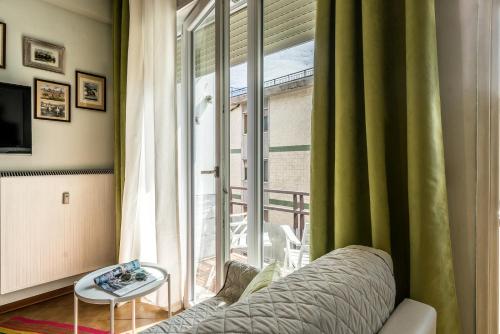 salon z kanapą i dużym oknem w obiekcie ARCA Conte Rosso Apartments w Mestre