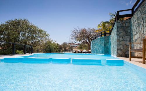a large swimming pool with blue water at Secret Harbour Boutique Hotel and Marina in Lance aux Épines