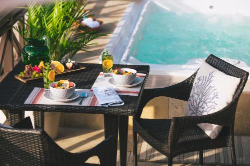 a table with food on it next to a swimming pool at Secret Harbour Boutique Hotel and Marina in Lance aux Épines