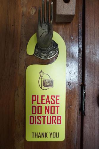 a sign on a door that says please do not disturb at Louto Dmell Villa & Guesthouse in Sanur