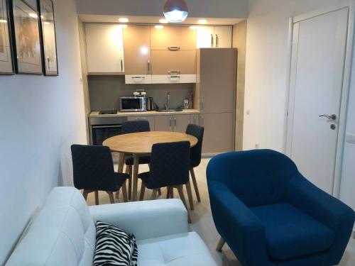 a living room with a table and a blue chair at Apartments Bane in Herceg-Novi