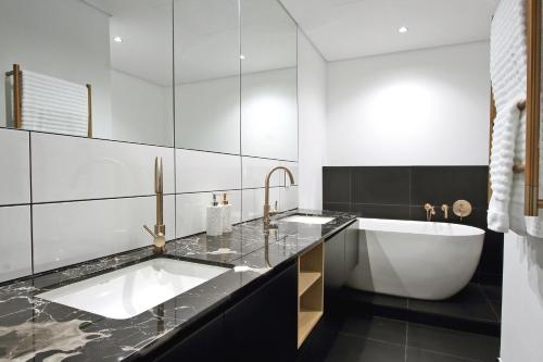 a bathroom with a bath tub and a sink at Penthouse Henning@The Onyx in Cape Town