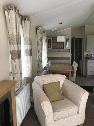 a living room with a couch and a table at Poppy at Oakdene Forest Park in Ringwood