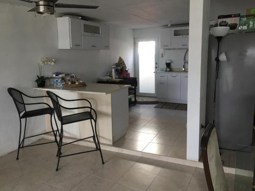 eine Küche mit 2 Stühlen und einer Theke in einem Zimmer in der Unterkunft El Yunque White House in Rio Grande
