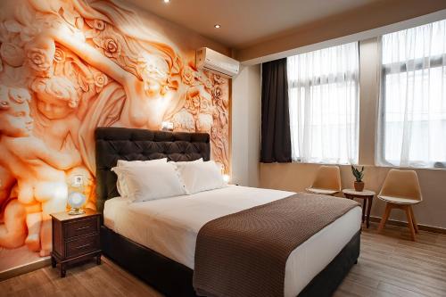 een slaapkamer met een groot bed en een muurschildering bij Pallada Athens boutique rooms & apartments in Athene