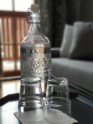 a bottle and two glasses on a table at Majątek Morgi in Suchowola