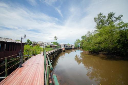 a bridge over a river with trees and buildings at Trat 101 Hotel - SHA Certified in Trat