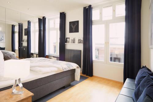 バーデン・バーデンにあるNo1 Apartment Baden-Badenのベッドルーム1室(ベッド1台、ソファ、窓付)
