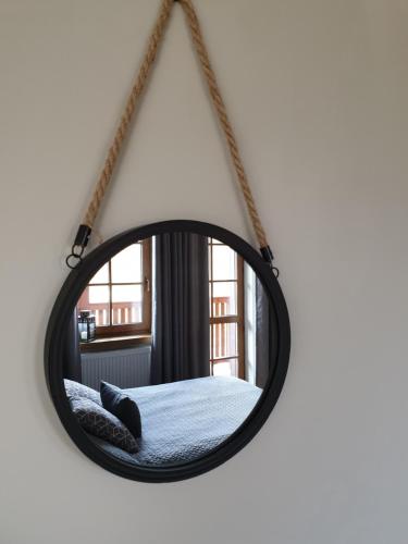 a hanging mirror with a bed in a room at Majątek Morgi in Suchowola