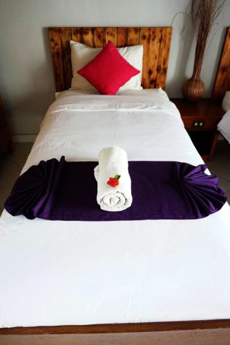 a white bed with a towel on top of it at Louto Dmell Villa & Guesthouse in Sanur