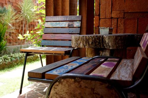 a bench sitting next to a table and a chair at Louto Dmell Villa & Guesthouse in Sanur