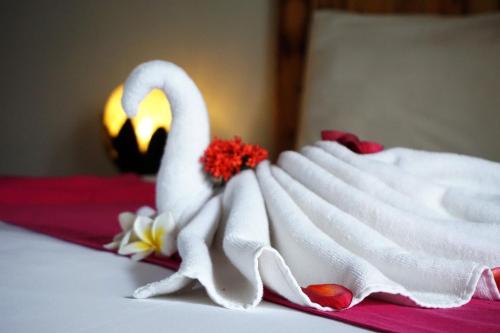 a swan made out of towels on a bed at Louto Dmell Villa & Guesthouse in Sanur