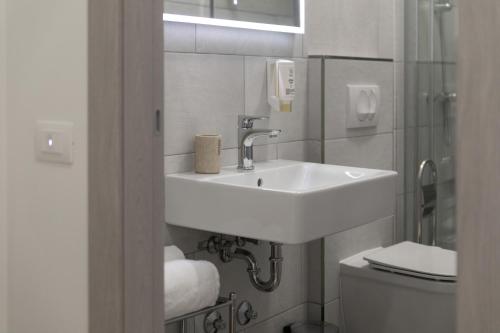 a white bathroom with a sink and a toilet at Preziosa in Pula