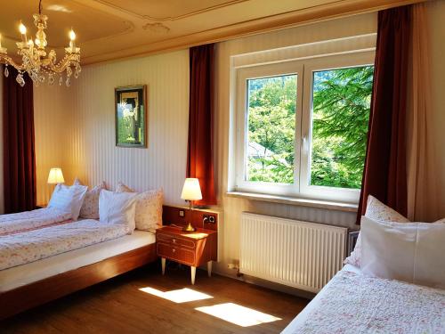 a bedroom with two beds and two windows at Aparthotel Pan Haus in Bad Ischl