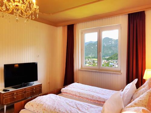 a hotel room with two beds and a window at Aparthotel Pan Haus in Bad Ischl