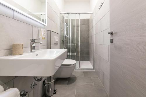 a bathroom with a sink and a toilet and a shower at Preziosa in Pula