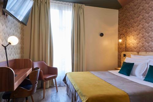 Cette chambre comprend un lit, un bureau et une fenêtre. dans l'établissement Hotel Konti Bordeaux by HappyCulture, à Bordeaux