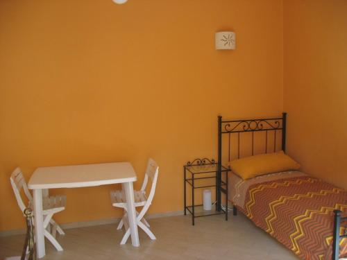 - une chambre avec un lit, un bureau et une table dans l'établissement "Casa di Angelica" - un'oasi di pace a 300m dal mare, à Gallipoli