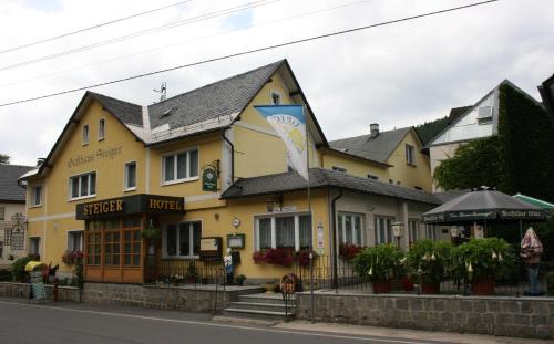 a yellow building on the side of a street at Hotel-Gasthaus Steiger in Gräfenthal