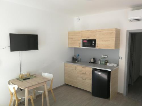 a small kitchen with a table and a black refrigerator at Alfa Riverside Brno in Brno