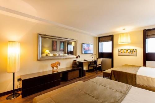 a hotel room with a bed and a desk at Quentin Prague Hotel in Prague