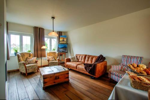 a living room with a couch and chairs and a table at Bed & Breakfast 't Vèèrke in Dilsen-Stokkem