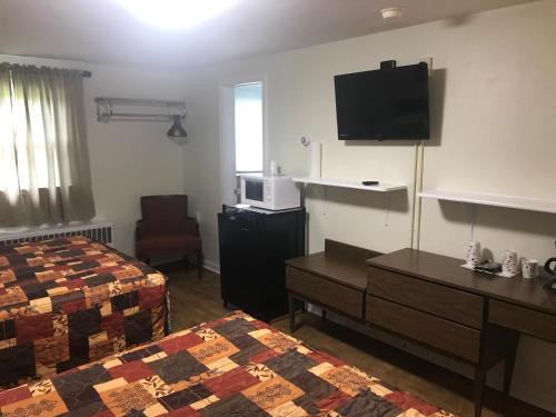 a hotel room with two beds and a flat screen tv at Evergreen Motel in Oswego