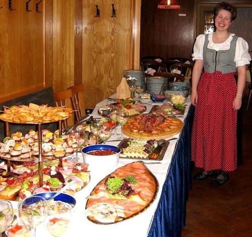 a woman standing in front of a table full of food at Hotel-Gasthaus Steiger in Gräfenthal