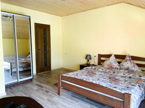 a bedroom with a large bed and a mirror at Апартаменти "Золота Баня" in Skhidnitsa